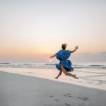 Young woman enjoying time at sea, jumping.